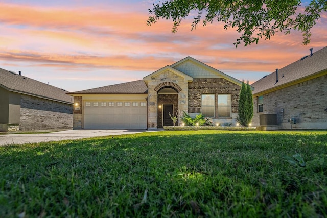 ranch-style house with a front lawn, stone siding, central AC, concrete driveway, and an attached garage