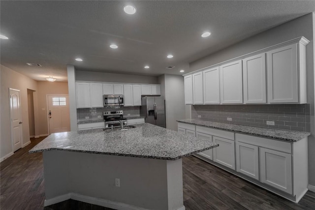 kitchen featuring stainless steel appliances, dark wood-type flooring, baseboards, tasteful backsplash, and white cabinetry