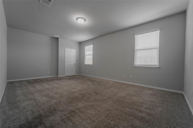 unfurnished room with baseboards, carpet flooring, and visible vents