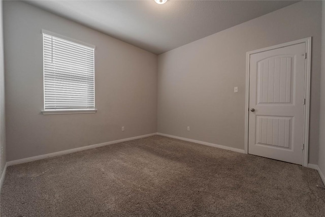 empty room featuring baseboards and carpet floors
