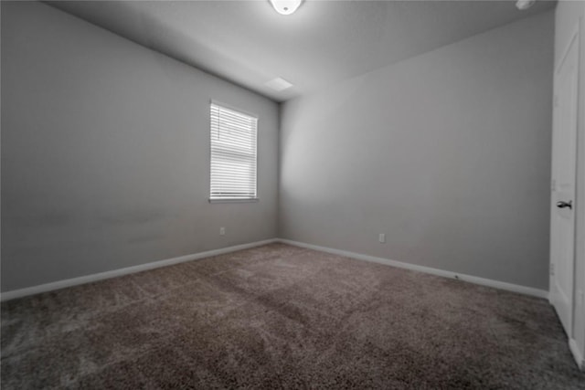 carpeted spare room featuring baseboards