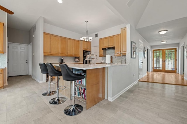 6659 Whitemarsh Valley Walk, Austin, TX 78746 - kitchen featuring decorative backsplash, light countertops, french doors, a chandelier, and a peninsula