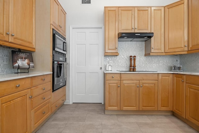 6659 Whitemarsh Valley Walk, Austin, TX 78746 - kitchen featuring black oven, under cabinet range hood, light countertops, and backsplash