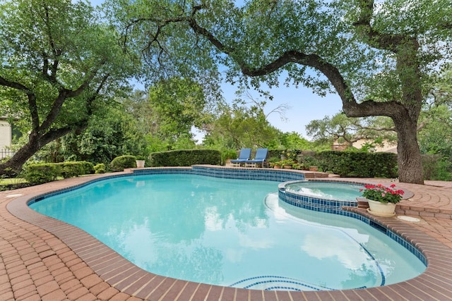 view of pool featuring a patio and a pool with connected hot tub