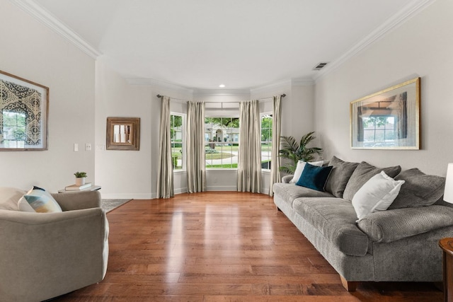 living area featuring visible vents, ornamental molding, wood finished floors, and a wealth of natural light