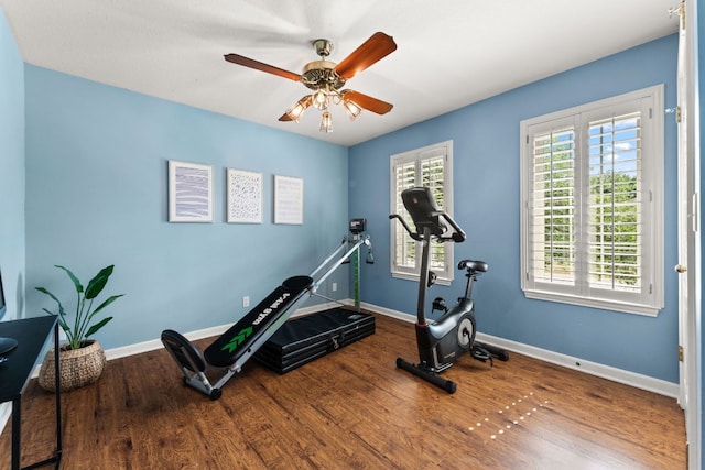 workout area featuring baseboards, ceiling fan, and wood finished floors
