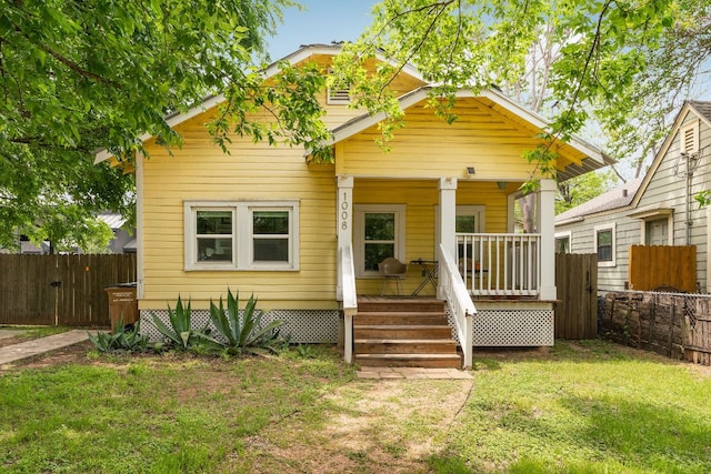 bungalow-style home featuring a porch, a front yard, and fence