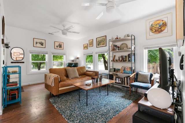 living area with a ceiling fan, baseboards, and dark wood finished floors