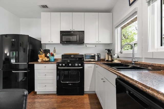 kitchen featuring white cabinets, a sink, and black appliances