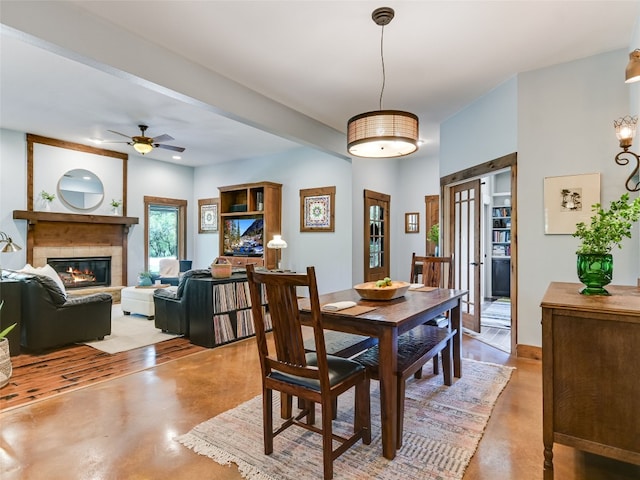 19904 Victoria Chase Rd, Lago Vista, TX 78645 - dining area with a glass covered fireplace, a ceiling fan, and concrete flooring