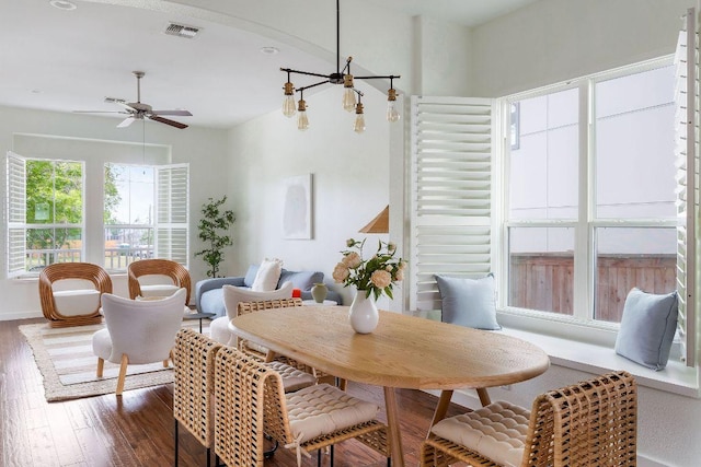 dining area featuring visible vents, wood finished floors, and ceiling fan with notable chandelier