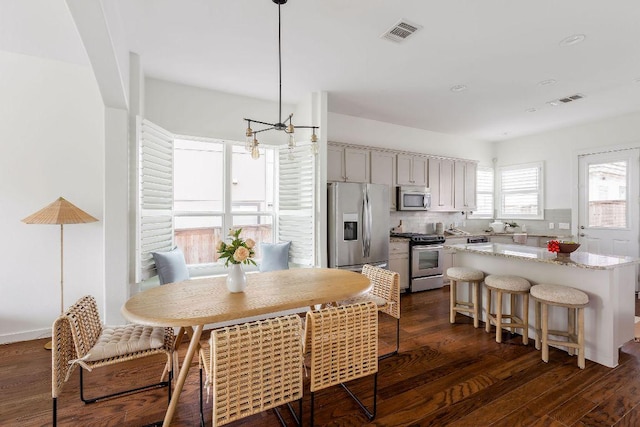 kitchen with visible vents, dark wood-type flooring, appliances with stainless steel finishes, and tasteful backsplash
