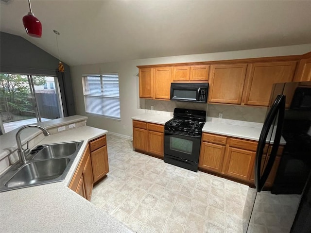 1709 Bush Coat Ln, Austin, TX 78754 - kitchen with black appliances, brown cabinetry, lofted ceiling, light countertops, and hanging light fixtures