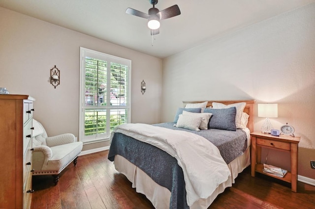 bedroom with a ceiling fan, baseboards, and dark wood-style flooring