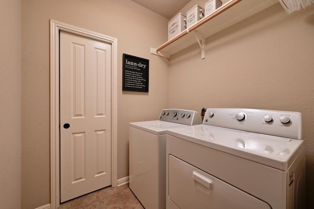 laundry area featuring separate washer and dryer, baseboards, and laundry area