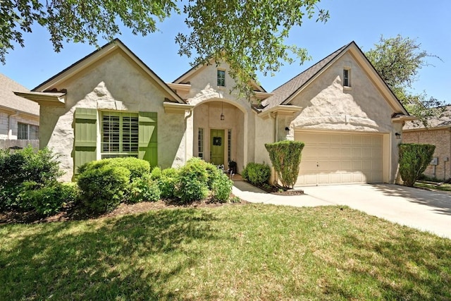 view of front of home featuring stucco siding, a front lawn, driveway, and a garage