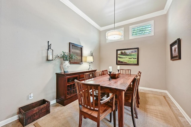 dining space featuring a towering ceiling, baseboards, and crown molding