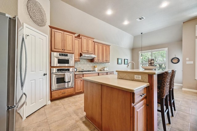 kitchen featuring backsplash, vaulted ceiling, visible vents, freestanding refrigerator, and gas stovetop