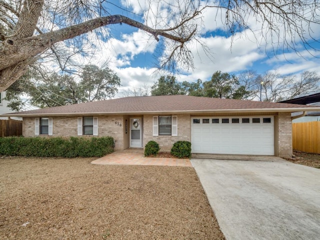 620 Lake Island Dr, Canyon Lake, TX 78133 - ranch-style house with an attached garage, driveway, brick siding, and fence
