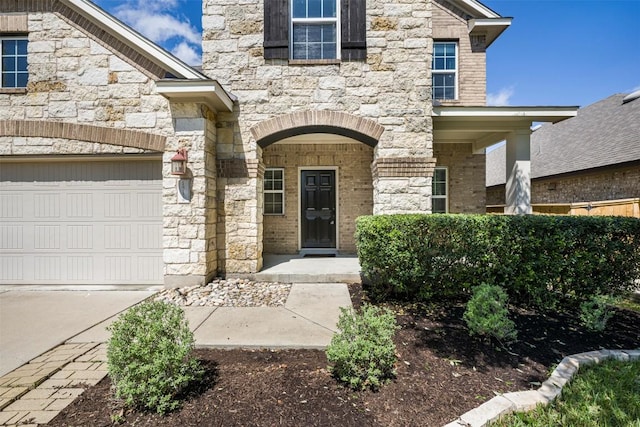 1812 Hidden Springs Path, Round Rock, TX 78665 - view of exterior entry with a garage, stone siding, and concrete driveway