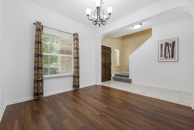 1812 Hidden Springs Path, Round Rock, TX 78665 - unfurnished dining area with stairway, wood finished floors, arched walkways, baseboards, and a chandelier