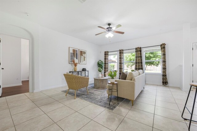 1812 Hidden Springs Path, Round Rock, TX 78665 - living area featuring light tile patterned flooring, a ceiling fan, baseboards, and arched walkways