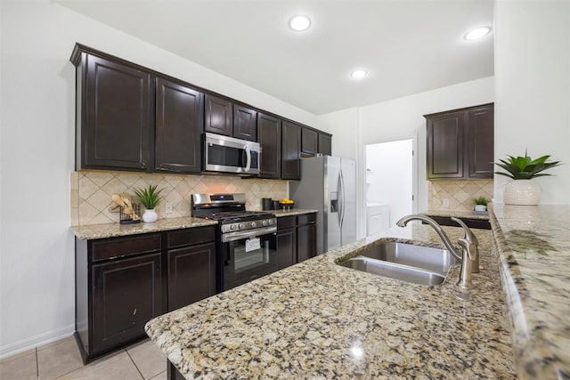 1812 Hidden Springs Path, Round Rock, TX 78665 - kitchen featuring stainless steel appliances, a sink, dark brown cabinets, decorative backsplash, and light stone countertops
