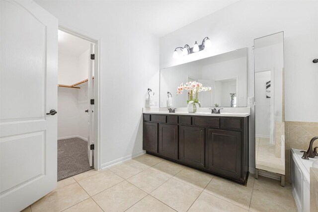 1812 Hidden Springs Path, Round Rock, TX 78665 - full bathroom with double vanity, a walk in closet, a garden tub, tile patterned floors, and baseboards