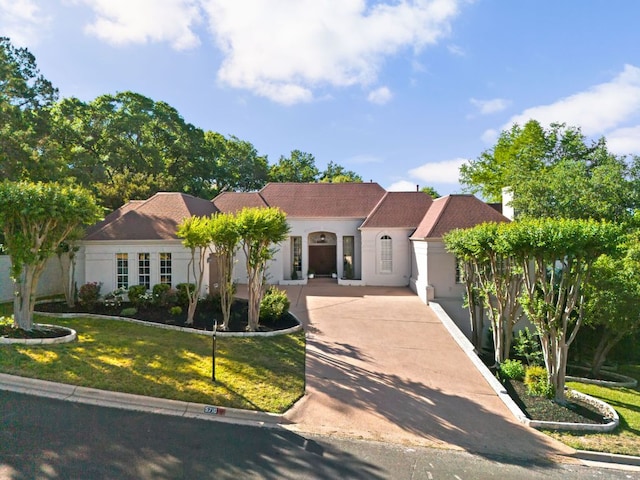 5710 Carry Back Ln, Austin, TX 78746 - mediterranean / spanish home featuring a front yard, stucco siding, and concrete driveway
