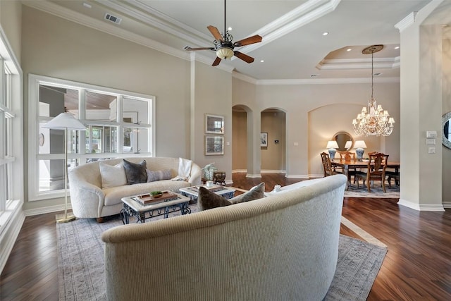 27435 Waterfall Hill Pkwy, Spicewood, TX 78669 - living room with visible vents, ceiling fan with notable chandelier, crown molding, arched walkways, and a raised ceiling