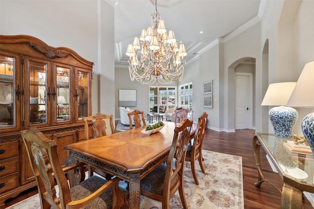 27435 Waterfall Hill Pkwy, Spicewood, TX 78669 - dining space with crown molding, dark wood-type flooring, baseboards, arched walkways, and a chandelier