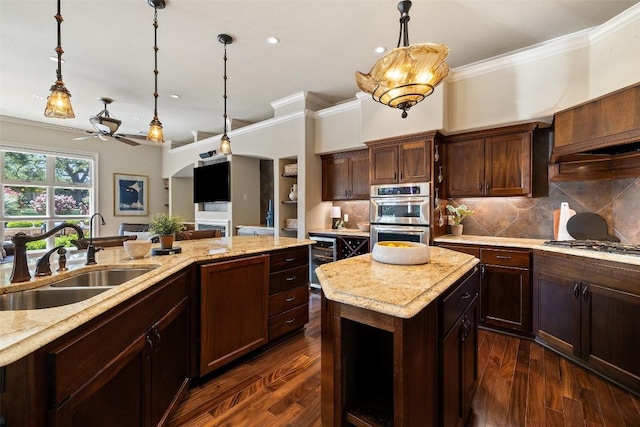 27435 Waterfall Hill Pkwy, Spicewood, TX 78669 - kitchen with stainless steel double oven, a ceiling fan, ornamental molding, and a sink