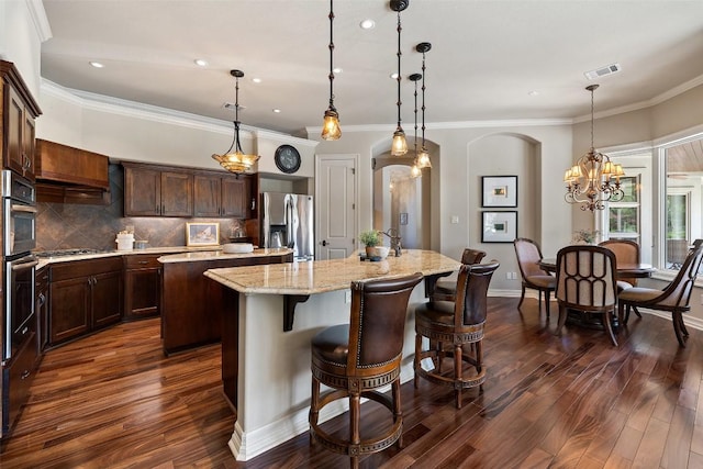 27435 Waterfall Hill Pkwy, Spicewood, TX 78669 - kitchen with stainless steel appliances, visible vents, decorative backsplash, arched walkways, and a kitchen island