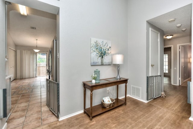 hallway featuring visible vents and baseboards