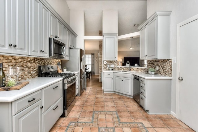 kitchen featuring a sink, stainless steel appliances, visible vents, backsplash, and light countertops