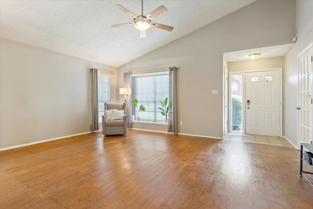 2203 Nathan Dr, Austin, TX 78728 - entryway with wood finished floors, a ceiling fan, high vaulted ceiling, and a textured ceiling