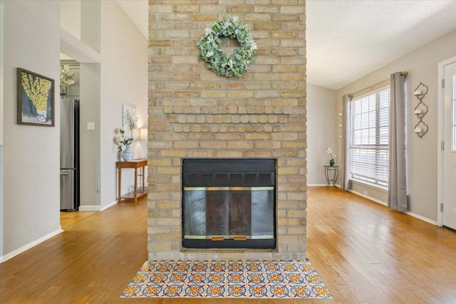 2203 Nathan Dr, Austin, TX 78728 - detailed view of freestanding refrigerator, wood finished floors, and a fireplace
