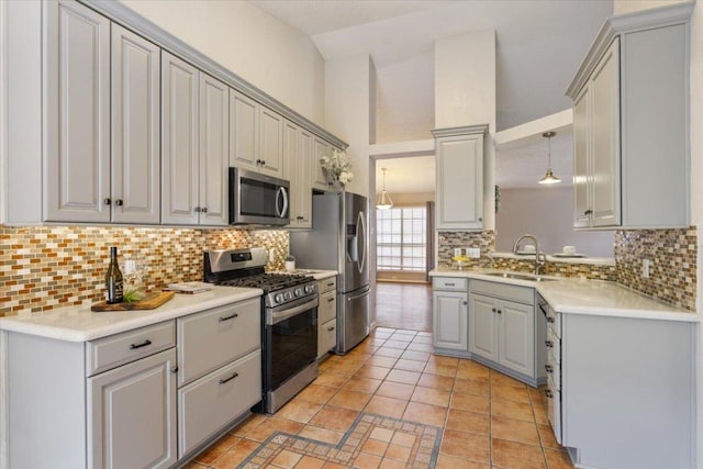 2203 Nathan Dr, Austin, TX 78728 - kitchen with stainless steel appliances, gray cabinetry, tasteful backsplash, light tile patterned flooring, and high vaulted ceiling