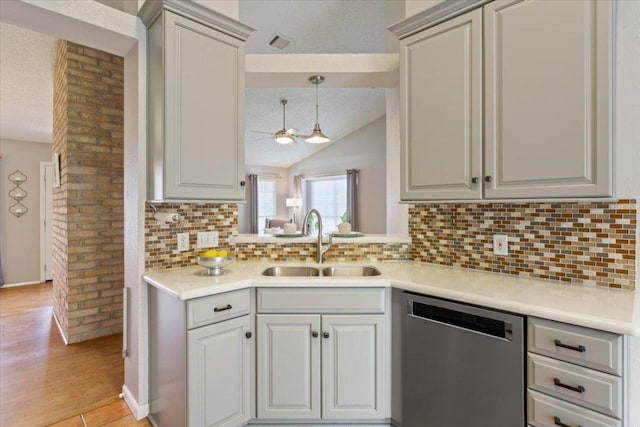 2203 Nathan Dr, Austin, TX 78728 - kitchen featuring dishwasher, lofted ceiling, light countertops, decorative backsplash, and light wood-type flooring