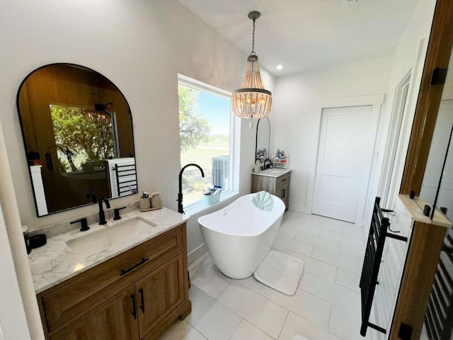 bathroom featuring plenty of natural light, a soaking tub, and vanity