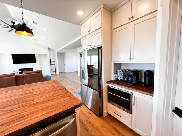 kitchen featuring wood counters, stainless steel appliances, visible vents, and light wood-type flooring