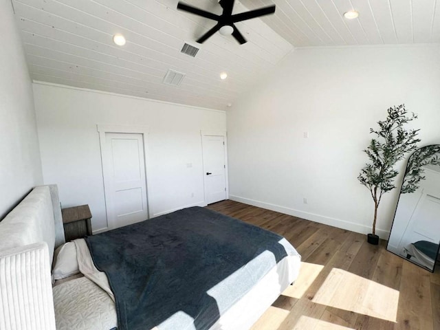 bedroom with vaulted ceiling, wood finished floors, wooden ceiling, baseboards, and visible vents