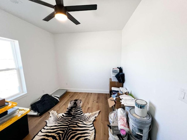 interior space featuring baseboards, wood finished floors, and ceiling fan