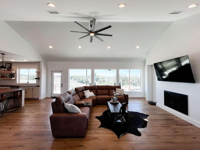 living room with baseboards, a glass covered fireplace, wood finished floors, and recessed lighting