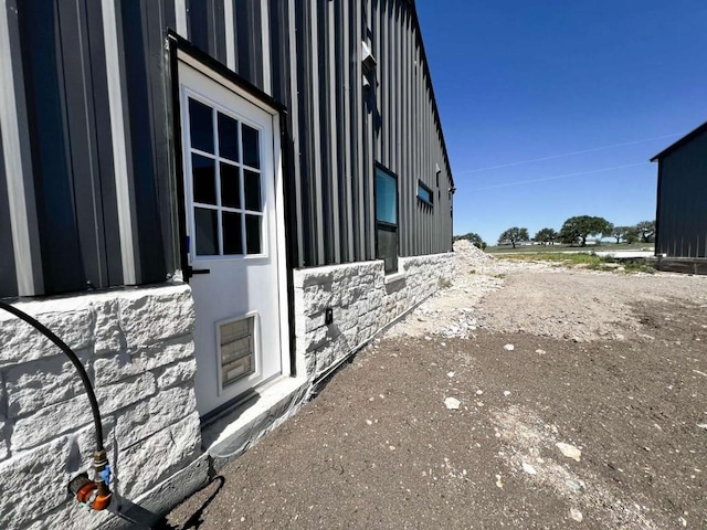 view of side of home with board and batten siding and stone siding