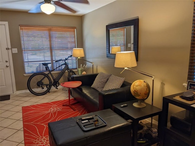 living room with a ceiling fan, baseboards, and light tile patterned floors