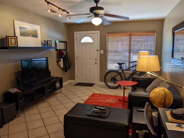 living area featuring light tile patterned floors, track lighting, baseboards, and ceiling fan