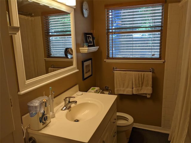 bathroom featuring curtained shower, toilet, and vanity