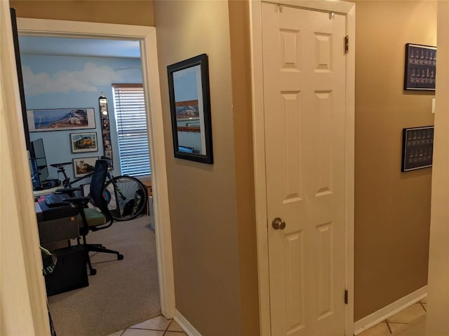 hall with baseboards and light tile patterned floors