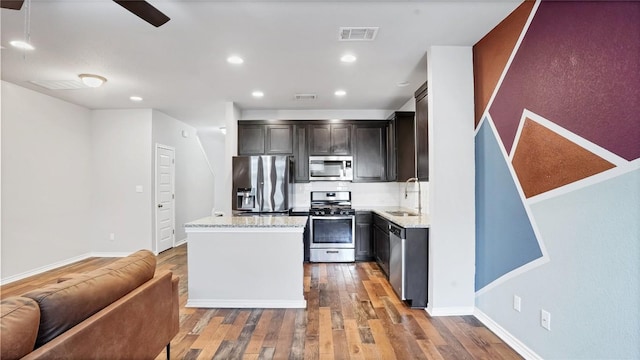 1837 Artesian Springs Xing, Leander, TX 78641 - kitchen featuring hardwood / wood-style flooring, visible vents, stainless steel appliances, a kitchen island, and backsplash